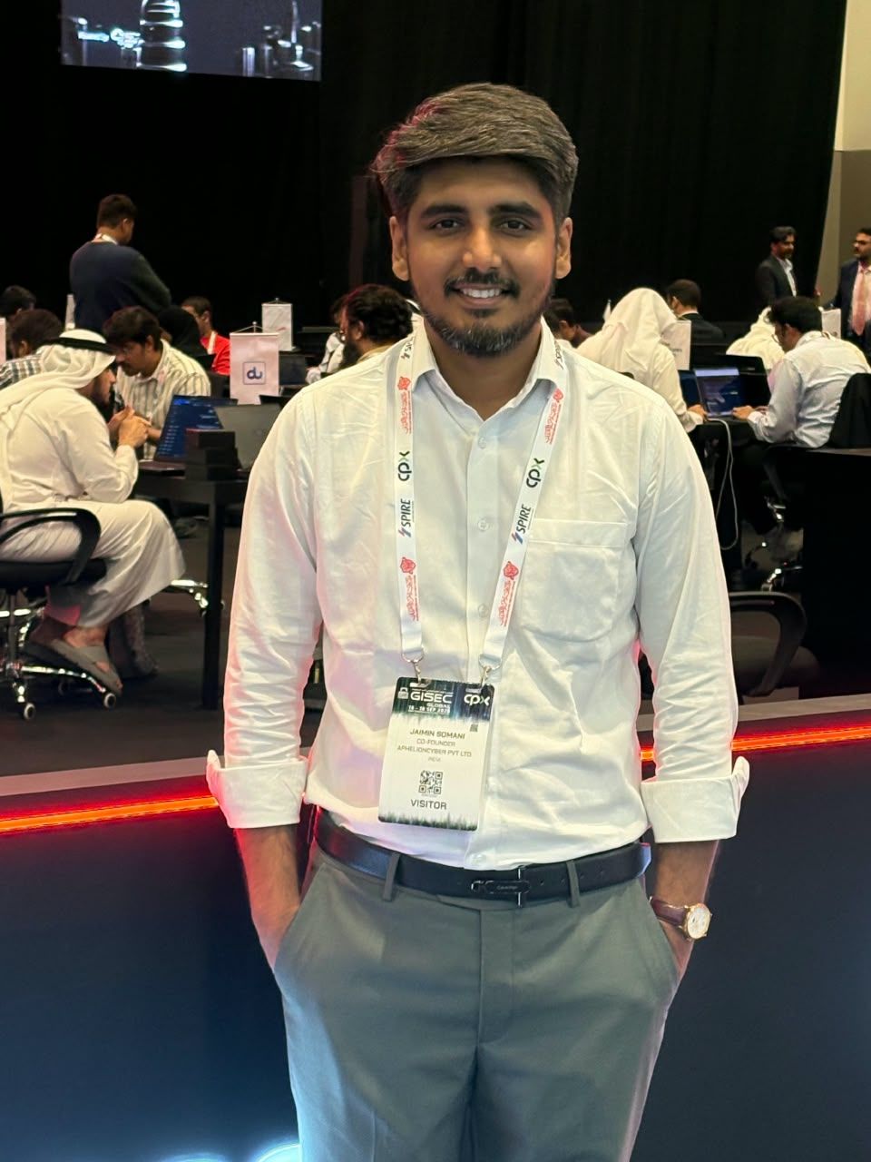 Jaimin Somani smiling at GISEC Global, wearing a white shirt and conference badge